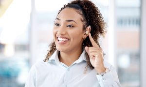 Happy, deaf and black woman with cochlear implant in office for communication, translation and spee